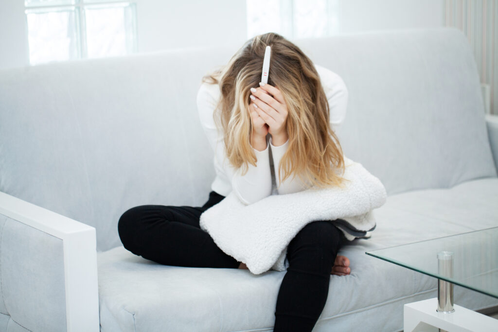 Pregnancy test. Worried sad woman Looking at a Pregnancy Test after result
